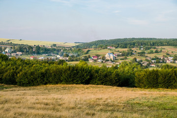 Fototapeta na wymiar Ukrainian village of Porokhova in the valley between the hills. Sunset panorama. Copy space.