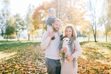 Happy family with their baby outdoor portrait. Father holding his little boy on shoulders.