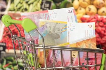 Einkaufswagen, Schweizer Franken und Lebensmittel