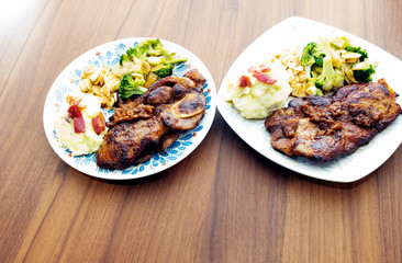 Pork steak with vegetables on a wood background