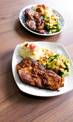 Pork steak with vegetables on a wood background