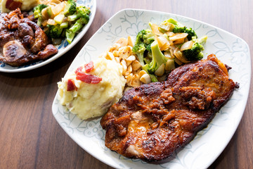 Pork steak with vegetables on a wood background