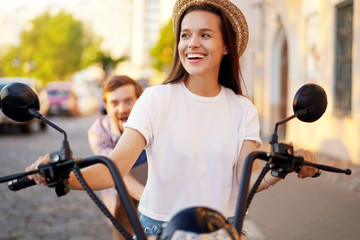 Fototapeta premium Couple in love riding a motorbike , Handsome guy and young sexy woman travel . Young riders enjoying themselves on trip. Adventure and vacations concept.