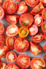 many red tomato slices on baking paper top view. cooking vegetables
