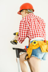 Woman drilling in wall