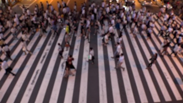 UMEDA, OSAKA, JAPAN - CIRCA JULY 2019 : Aerial blurred view of zebra crossing near Osaka train station. Crowd of people at the street. Shot in busy rush hour. Slow motion.