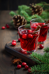 Mulled red wine with cranberries. Holiday Concept Decorated with Fir Branches and Cones.