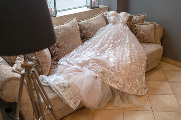 Fototapeta na wymiar White weeding dress lying on bed in hotel.