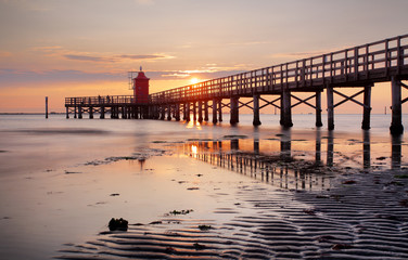 Beach with lighthouse in Italy resort Lignano at sunrise