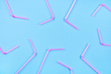 Pink cocktail straws on a color background.