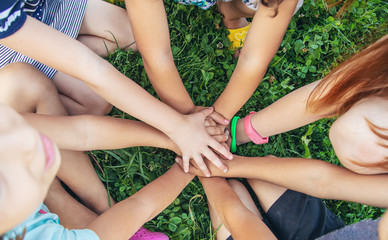 children's hands together on a background of grass. Selective focus.