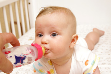 newborn european baby girl boy eats bottle nipple