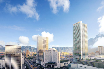 Naklejka premium The modern city with skyscrapers and mountains