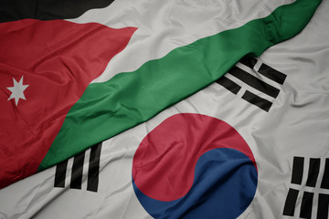 waving colorful flag of south korea and national flag of jordan.