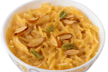 Vermicelli dessert, popular sweet dish know a kheer made with milk and garnish with dry fruits isolated on white background, served in bowl. Selective focus. Top view.