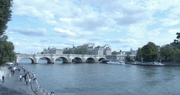 Time Lapse of Pont Neuf, the famous bridge over the river Seine, viewed from the Quai du Louvre, with a tourist boat driving by