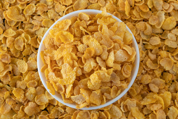 Cornflakes in blowl, healthy corn flakes background a delicious dietary breakfast cereal. Top View