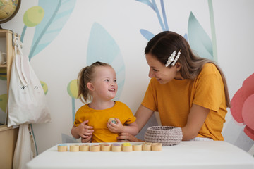 mother plays with sensory toys with child disabled