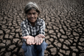 Elderly women make hands to get rainwater in dry weather, global warming, selected focus.