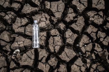 Water bottles on dry soil with dry and cracked soil,global warming
