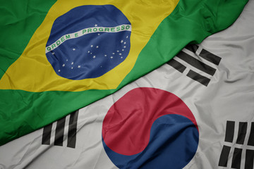 waving colorful flag of south korea and national flag of brazil.