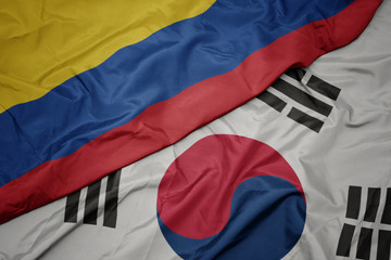 waving colorful flag of south korea and national flag of colombia.