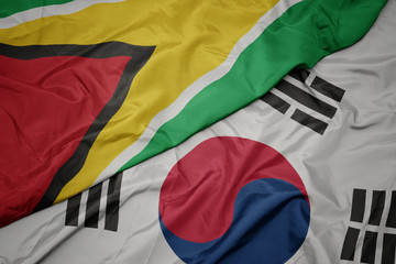 waving colorful flag of south korea and national flag of guyana.
