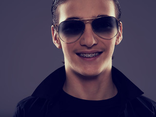 Obraz premium Smiling Handsome fifteen years old guy in a black stylish sunglasses.