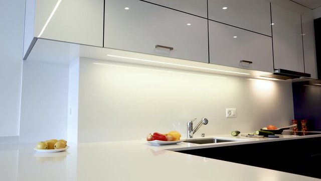 Kitchen cabinets with kitchen counter top of modern home interior design. Cabinet doors are made of white flat  wooden boards and countertops are made of the natural granite or marble.