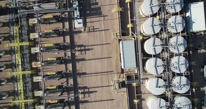 Natural gas pad with drone rising up directly looking down.