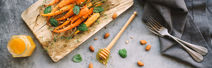Baked carrots with spices and herbs. Light gray background. Copy space
