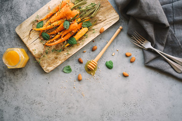 Baked carrots with spices and herbs. Light gray background. Copy space