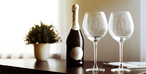 empty glasses and a bottle of wine or champagne on the table at