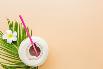 Palm leaf and coconut on pastel orange background, top view. Mockup, overhead. Flat lay image with copy space. Summer and tropical concept
