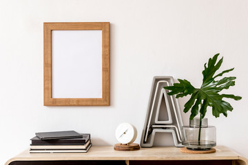 Modern home interior design with mock up photo frame, wooden commode, books, tropical leaf, big...