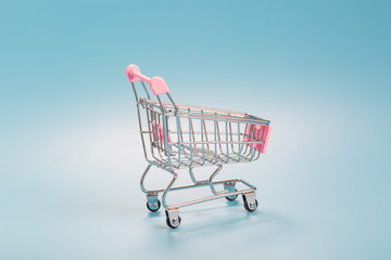 Shopping cart over blue green background