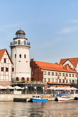 Fototapeta premium Kaliningrad, Russia - August 24, 2019: View of the Fish Village and lighthouse on the embankment of the Pregolya River.