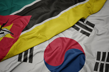 waving colorful flag of south korea and national flag of mozambique.