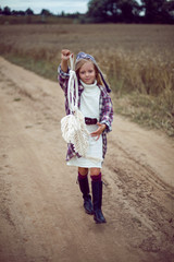 blonde girl in white in a dress and boots goes with a dream catcher