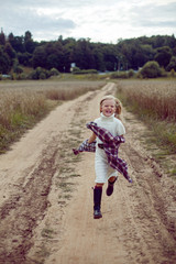Fototapeta premium blonde girl in white in a dress and boots goes with a dream catcher