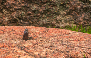 Ancient millstone with a rusty metal axis