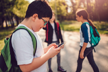 Boy using smart phone at schoolyard