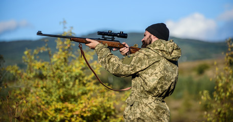 Focus and concentration of experienced hunter. Hunting and trapping seasons. Hunting masculine hobby. Man brutal gamekeeper nature background. Hunter hold rifle. Bearded hunter spend leisure hunting
