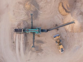 aerial view of a quarry with conveyor belt and wheel loader - stones and sands for construction - top view , open pit mine, extractive industry
