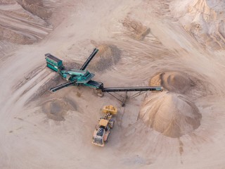 aerial view of a quarry with conveyor belt and wheel loader - stones and sands for construction - top view , open pit mine, extractive industry