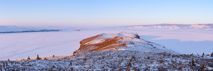 Dawn on the island of Ogoy overlooking the snow-covered ice of Lake Baikal and a stupa of education, established to attract tourists.