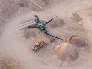 aerial view of a quarry with conveyor belt and wheel loader - stones and sands for construction - top view , open pit mine, extractive industry