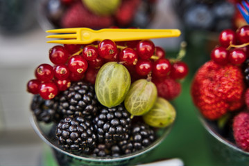 Blueberry, little cherries an green grapes in plastic cups at street market