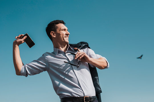 Office worker throwing his smartphone away while having a rest