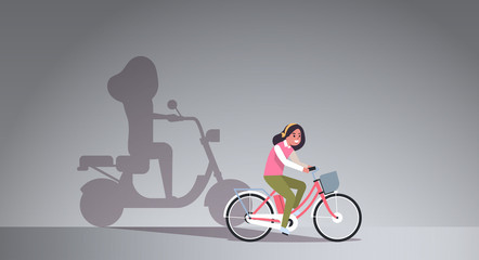 Fototapeta na wymiar casual girl riding bike shadow of woman on motor scooter imagination aspiration concept female cartoon character full length flat horizontal